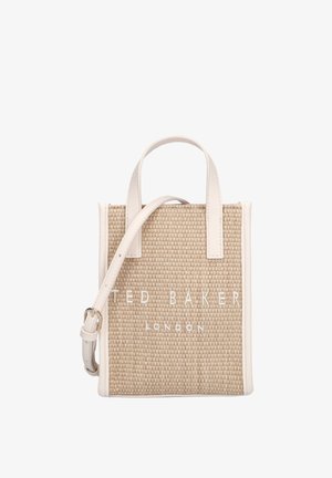 Small beige woven tote bag with white leather handles and strap, "Ted Baker London" embroidered on front.
