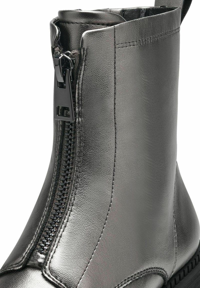 Bottine en cuir gris métallique avec fermeture éclair sur le côté, texture en cuir lisse et semelle en caoutchouc noir robuste. Dotée d'un bout rond.