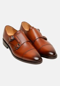 Braune Leder-Doppelschnallen-Schuhe mit polierter Oberfläche, runder Zehenform und silverfarbenen Schnallen. Glatte Textur und strukturiertes Design.