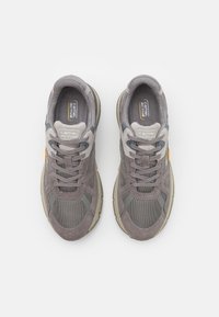 Gray suede and mesh sneakers with durable rubber soles, featuring gray accents and a logo tag. Laced design with padded collar.