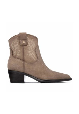 Bota vaquera de ante marrón claro hasta el tobillo con costuras decorativas, una lengüeta para tirar y un tacón bajo apilado sobre un fondo blanco.