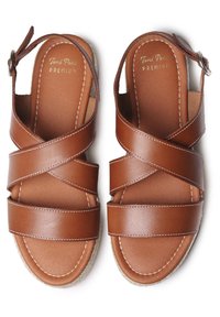 Sandali in pelle marrone con cinturini incrociati, dotati di una soletta imbottita e di una suola in juta intrecciata. Marchio dorato sulla soletta.