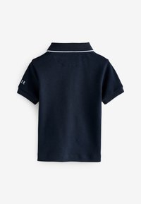 Marineblauwe polo met korte mouwen, witte bies op kraag en mouw, achterkant zichtbaar, met gedeeltelijke witte tekst op de linkermouw.