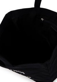 Black fabric tote bag with an open top, interior zippered pocket, and visible partial white text on the exterior.