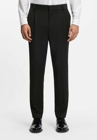 Pantaloni formali neri con vestibilità su misura, davanti piatto e dettaglio della piega. Indossati con una camicia bianca e scarpe eleganti nere lucide.