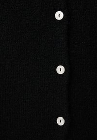 Zwarte gebreide cardigan met een gestructureerde stof en vijf witte ronde knopen aan de voorkant. Het materiaal ziet er zacht en pluizig uit.