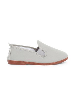 Chaussure slip-on en toile grise avec des goussets élastiques, un bout arrondi et une semelle en caoutchouc marron. Design minimaliste sans motifs ni accents visibles.