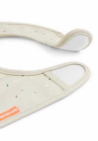 Spallina in silicone beige con granelli verdi e bianchi sparsi, caratterizzata da una superficie liscia e un rivestimento in tessuto bianco su un bordo.