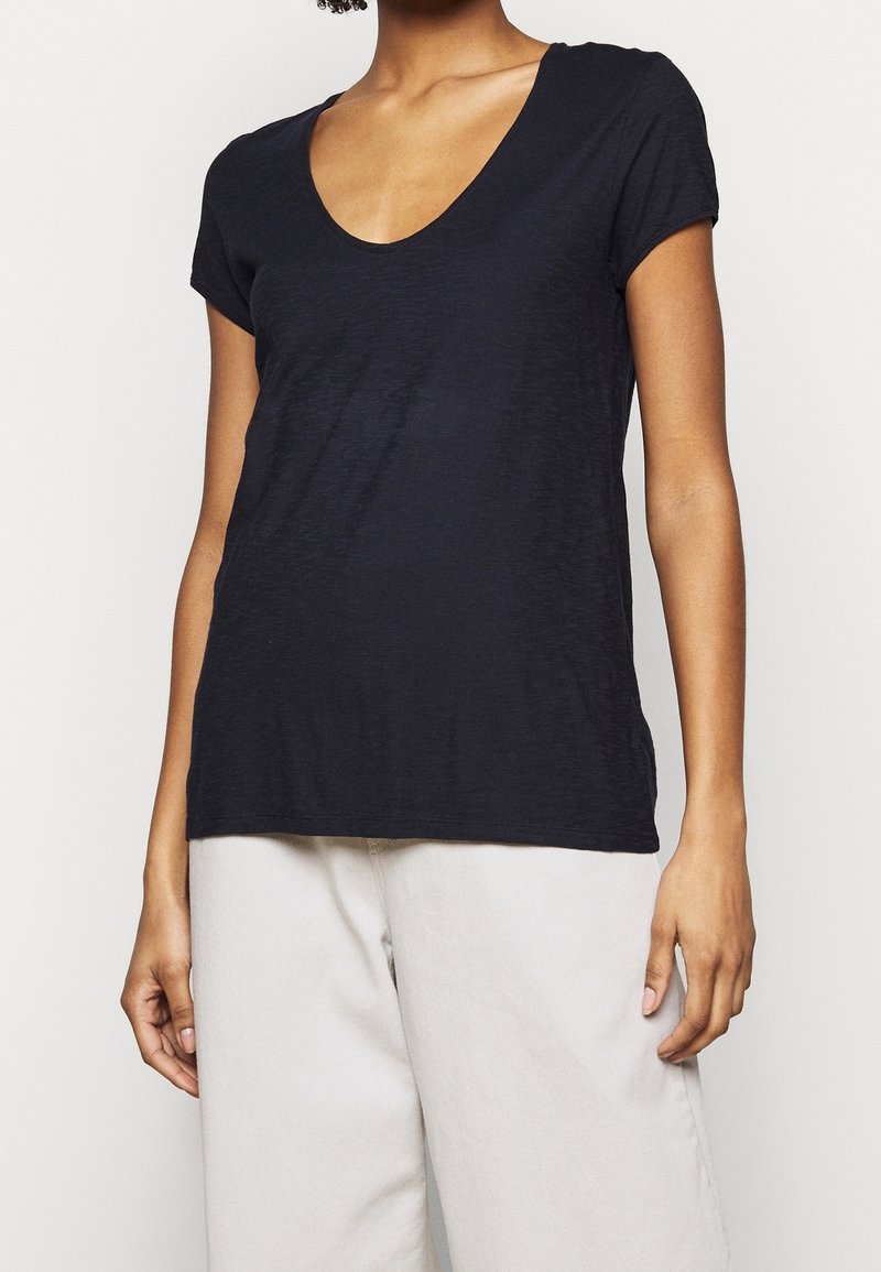 Black, short-sleeve t-shirt with a deep V-neck and a relaxed fit, made from soft, textured fabric. Simple and versatile design.