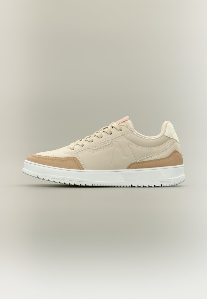 Beige szintetikus felsőrészes sneaker, velúr részletekkel, fehér talppal, kontrasztos rózsaszín sarokfüllel és texturált részletekkel az oldalakon.