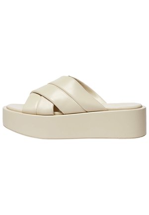 Sandales plateforme beiges avec trois larges brides croisées en matériau synthétique lisse et une semelle épaisse et solide. Design minimaliste.