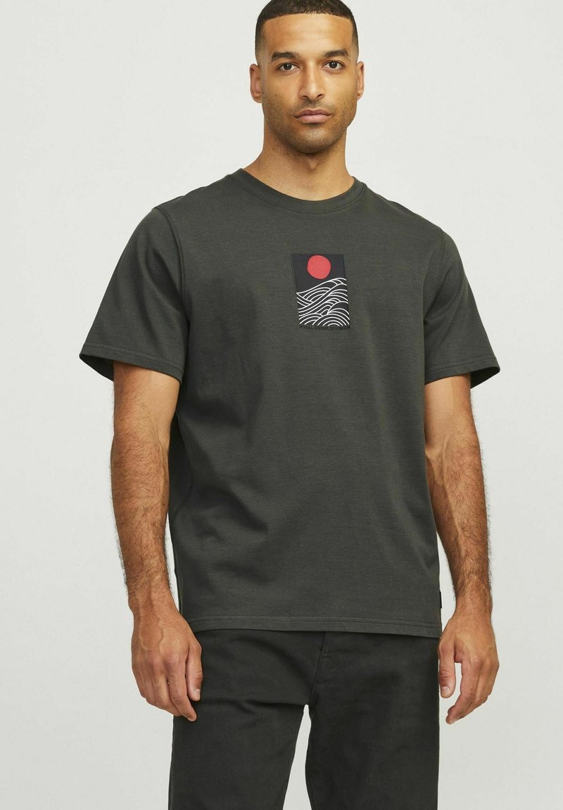Dark grey t-shirt made of cotton, featuring a graphic design with a red sun and wavy lines on the front. Short sleeves and crew neckline.