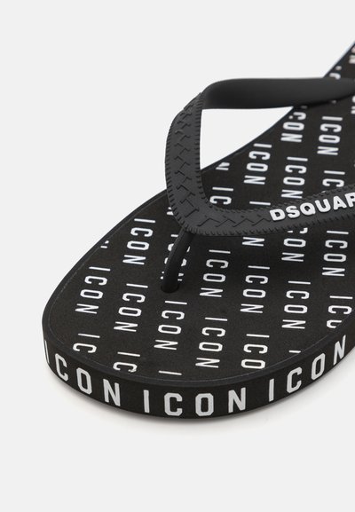 Sort gummiflip-flop med strukturerede stropper. Sålen har gentaget hvid "ICON" branding. Slank design med flad profil.