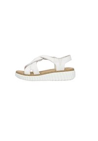 White leather sandals featuring crossed straps, open toe design, and a cork insole. The sole has a textured white rubber with ridges.