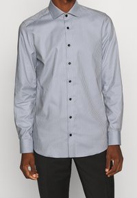 Lange mouw knoopshirt in lichtblauw met fijne witte strepen, voorzien van zwarte knopen en een klassiek kraagontwerp. Gladde textuur.