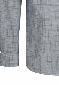 Camicia a maniche lunghe grigia a scacchi con tessuto strutturato, orlo leggermente curvo, polsini con bottoni e dettagli di cucitura sottili.