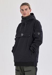 Zwarte pulloverjas met een hoge kraag, verstelbare trekkoorden, voorzak met klep, logo-detail en geribde manchetten. Glad materiaalafwerking.