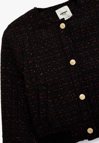 Czarna i burgundowa teksturowana kurtka z okrągłym dekoltem, złotymi guzikami i widocznymi wzorami szwów. Ma dopasowany krój oraz boczne kieszenie.