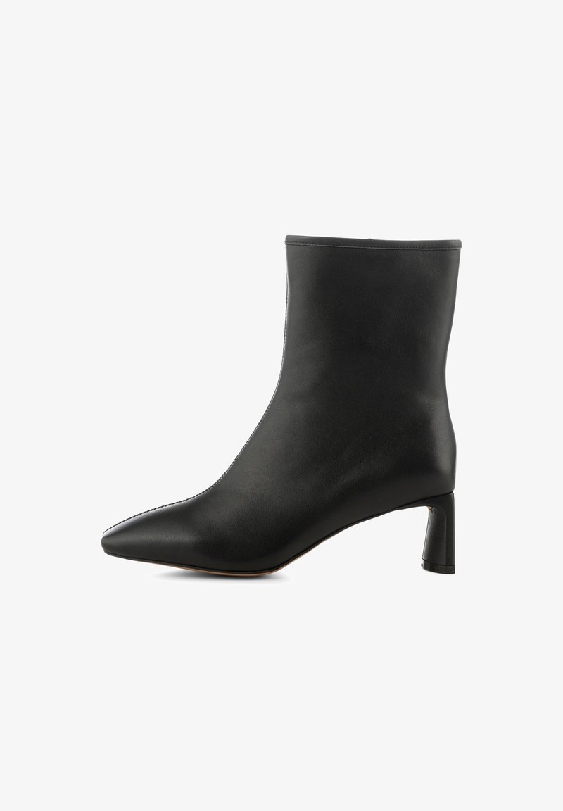 Botte pour femme en cuir noir mi-mollet avec bout pointu et talon bloc sur fond blanc.