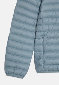 Maniche di giacca a vento azzurro chiaro con motivo a righe orizzontali, polsini elastici e dettaglio con tasca con zip sul lato.