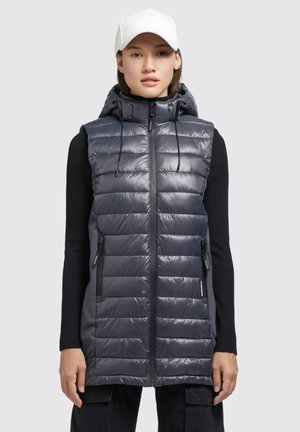 Gilet rembourré bleu marine avec capuche, fermeture éclair à l'avant et poches latérales. Présente une texture lisse et brillante avec un motif matelassé horizontal.