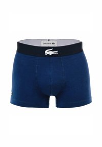 Boxers en coton bleu marine avec une taille noire arborant un logo Lacoste blanc et un petit emblème de crocodile vert sur la jambe.