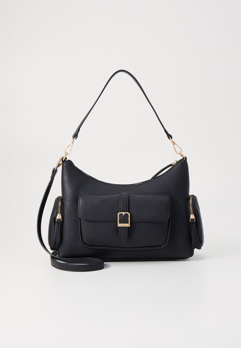 Sac à main en cuir noir avec une silhouette courbée, poche avant avec une boucle en métal, compartiments zippés sur les côtés et une bandoulière amovible.