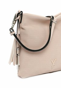 Borsa a tracolla in pelle perforata di colore rosa chiaro con tracolla nera a contrasto, caratterizzata da una superficie testurizzata e dettagli in frange per maggiore dimensione.