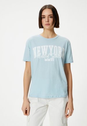 Lichtblauw katoenen t-shirt met een ronde halslijn, korte mouwen en witte opdruk met de tekst "NEW YORK Verenigde Staten MMVI."