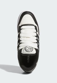 Basketbalové tenisky v černobílé barvě, které mají kožený svršek, perforovanou špičku, bílé tkaničky a kulatou nášivku na jazyku.