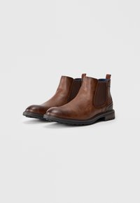 Brown leren Chelsea boots met elastische zijkanten, ronde neus en gestructureerde afwerking. Platte rubberen zool met een lichte hak. Casual ontwerp.