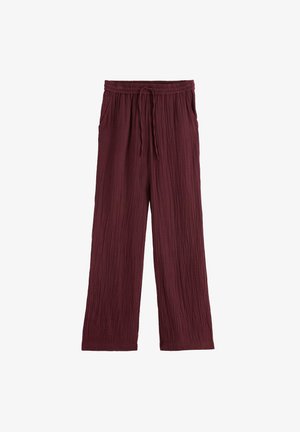 Pantalon large bordeaux avec texture froissée, taille élastique et cordon de serrage, avec poches latérales.