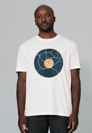 Weißes T-Shirt mit einem großen kreisförmigen Design, das einer Vinyl-Schallplatte ähnelt, in dunkelblauen und hellbraunen Farben, mit einer abgenutzten Textur.