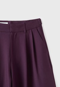Dark purple high-waist trousers with belt loops and pleats on the front, shown against a light gray background.