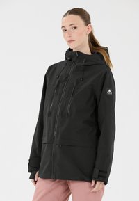 Schwarze wasserdichte Jacke mit Frontreißverschluss, verstellbarer Kapuze und zwei Reißverschlusstaschen auf der Brust. Verfügt über Klettverschlussmanschetten und ein Logo-Patch am Ärmel.