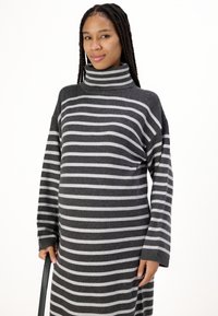 Robe en tricot rayée grise et gris clair avec un col roulé haut, une coupe décontractée, des manches longues et des poignets côtelés. Texture en tricot douce.