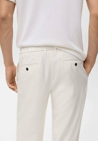 Pantaloni in lino bianchi con una vestibilità rilassata, dotati di vita con cordoncino e due tasche posteriori con dettagli in bottone nero.
