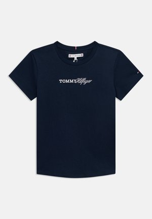 Mörkblå bomullst-shirt med rund hals, korta ärmar och en vit "TOMMY HILFIGER"-logotyp tryckt på bröstet. Slät textur.