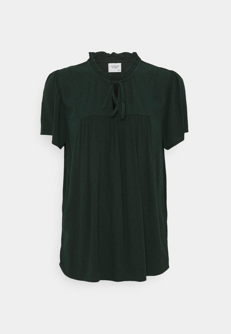 Blusa corta a maniche corte verde scuro con colletto arricciato, dettaglio a nastro sul collo e motivo a pois discreto. Vestibilità leggermente ampia con dettagli arricciati.
