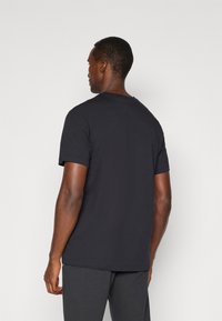 Sort bomulds T-shirt med korte ærmer, rund hals og lige skæring. Glat tekstur, ingen synlige mønstre eller accenter.