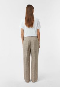Pantaloni a vita alta in tessuto scozzese beige e marrone con motivo a quadri, caratterizzati da una vestibilità rilassata e due tasche posteriori con cuciture decorative.