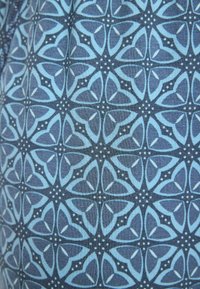 Marine stoffen met een geometrisch patroon met lichtblauwe bloemmotieven en kleine stipaccenten, die een getextureerd visueel effect creëren.