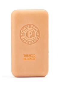 Pfirsichfarbige rechteckige Seife mit abgerundeten Kanten, geprägtem Logo und dem Schriftzug "TOBACCO BLOSSOM" in dunkelorange. Glatte Textur, minimalistisches Design.