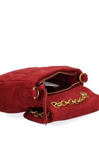 Sac à main en daim rouge avec une texture matelassée, orné d'une chaîne dorée et d'une fermeture éclair. Poche intérieure visible.
