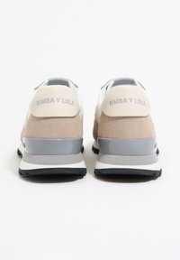 Sneakersy Bimba y Lola z beżową cholewką z zamszu, jasnoniebieskimi akcentami i szarą gumową podeszwą. Charakterystyczne oznaczenie marki na pięcie, warstwowy design i teksturowane materiały.