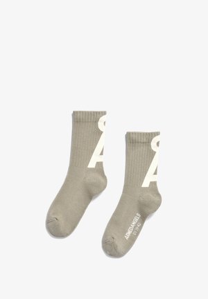 Chaussettes côtelées kaki avec le logo blanc 'A' sur le côté et la marque sur la pointe. Texture douce et design mi-mollet.