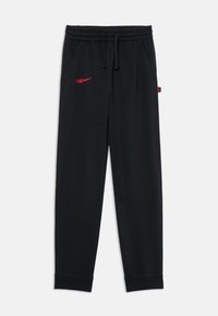 Crne trenirke od mekanog materijala, s elastičnom širim u struku, bočnim džepovima i crvenim Nike logotipom s lijeve strane.