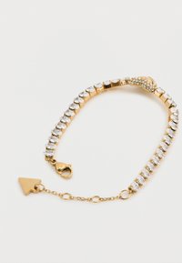 Βραχιόλι σε χρυσή απόχρωση με καθαρά, λαμπερά στρας σε ευέλικτο σχέδιο. Διαθέτει κούμπωμα σε σχήμα αστακού και διακοσμητικό σε σχήμα βέλους.