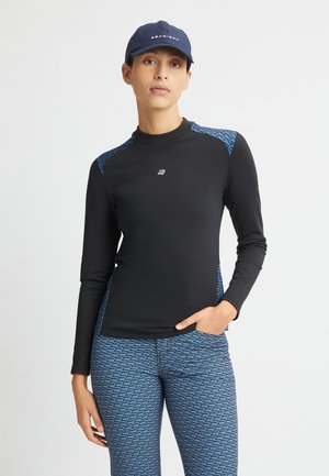 Langärmliges schwarzes Sportoberteil mit blauen gemusterten Akzenten an den Schultern, kombiniert mit blauen Leggings mit geometrischen Musterungen.