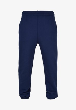 Navy blue sweatpants made of soft cotton blend. Features elastic waistband and cuffed ankles. Includes side pockets. Simple design.